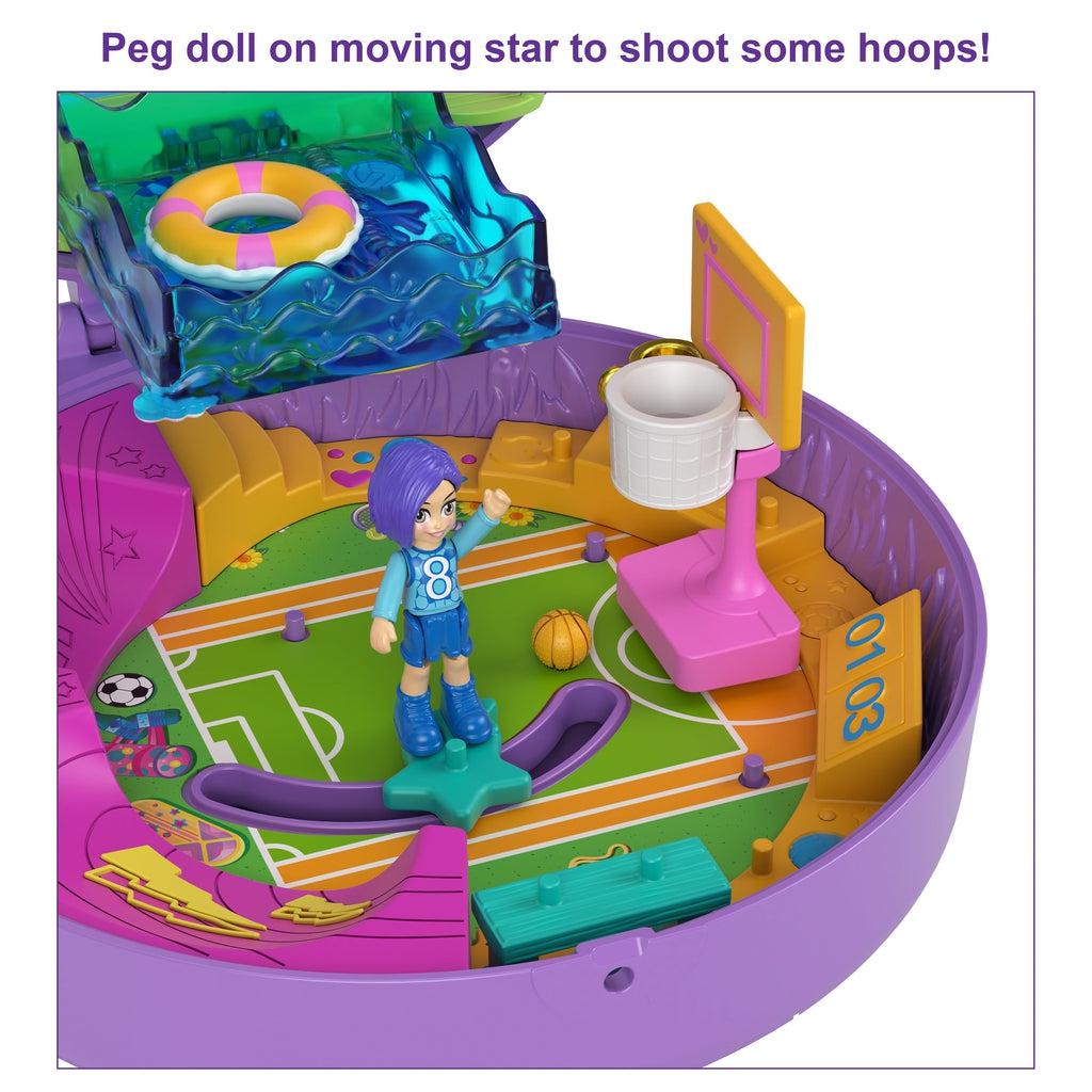 Shows the bottom of the compact. It looks like a field/court on the floor with multiple places to put the included pieces. On the floor in a moving star to assist your Polly Pockets in scoring.