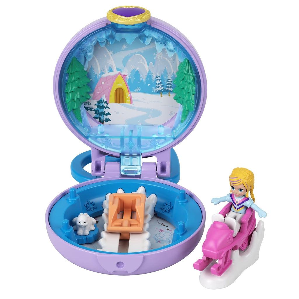 Image of the winter themed Tiny Compact. It includes a Polly Pocket dressed for snow and a snowmobile. In the inside it has a picture of a log cabin, a baby polar bear, and a sled.