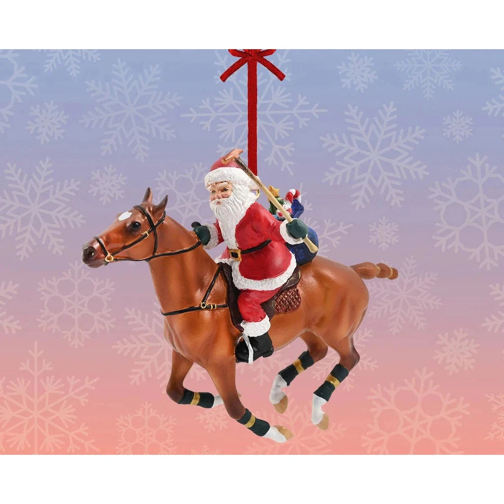 the polo playing santaf is santa riding a horse for a Christmas ornament.  blue and red background