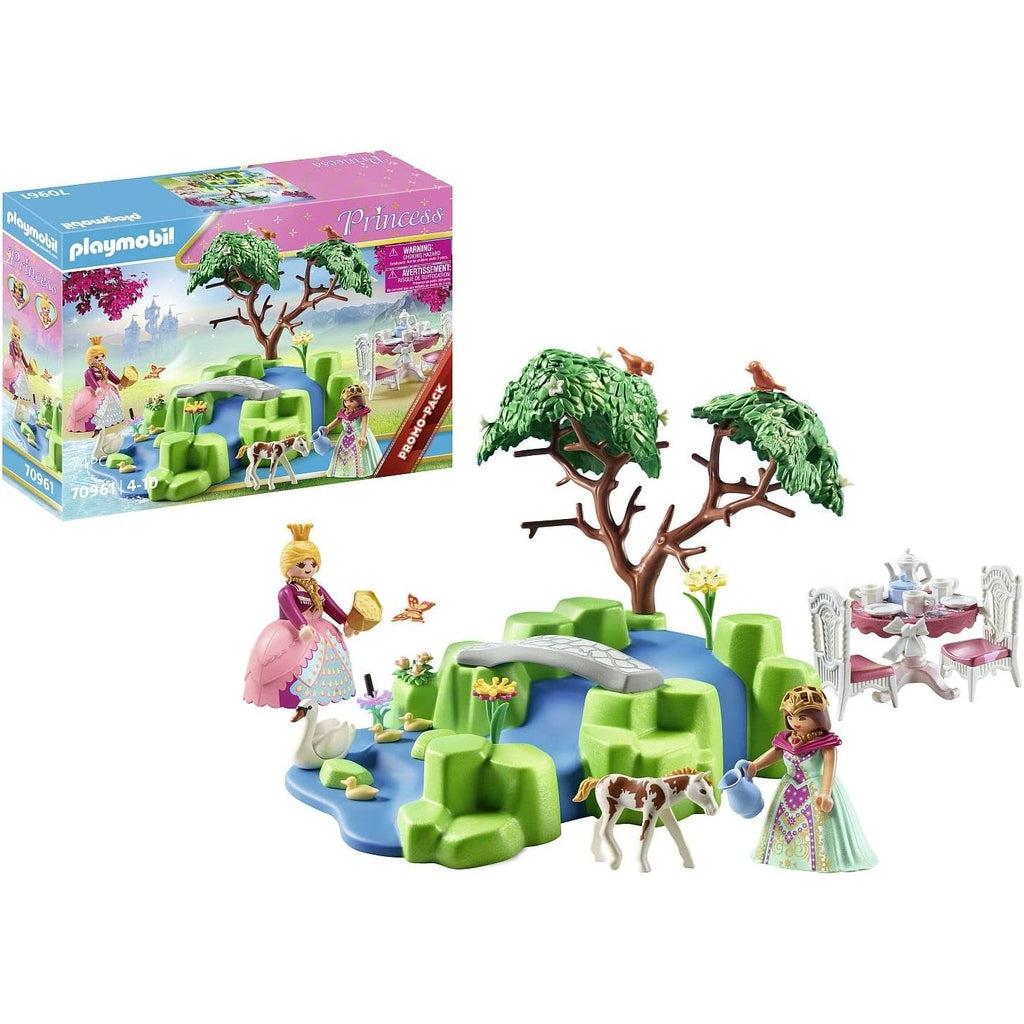 The box is in the background and all the play pieces are in the front, showing that is included, displaying the garden play area and the tea table