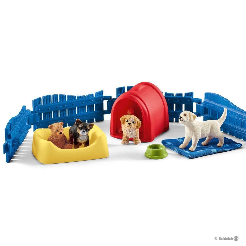 Image of the play set outside of the packaging. It comes with a blue fence, a red dog house, a dog bed, a teddy bear, and three different dogs.
