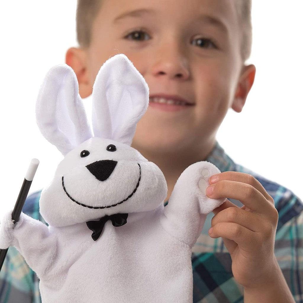 this image shows a young magician playing with the rabbit and wand