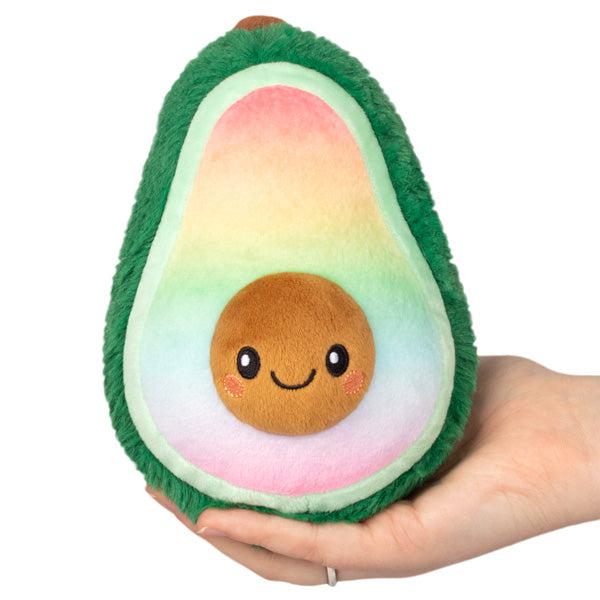 Image of the Rainbowcado Snacker sqiushable. It is an avocado plush with the flesh of the fruit colored as a rainbow.