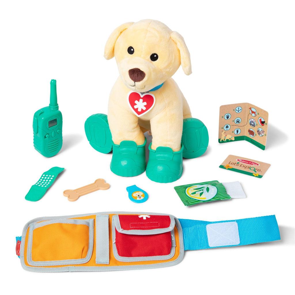 Image of all the included set pieces. It includes a golden retriever dog plush, set of shoes, a fake walkie talkie, pretend first aid supplies, and a wearable belt for your kid.