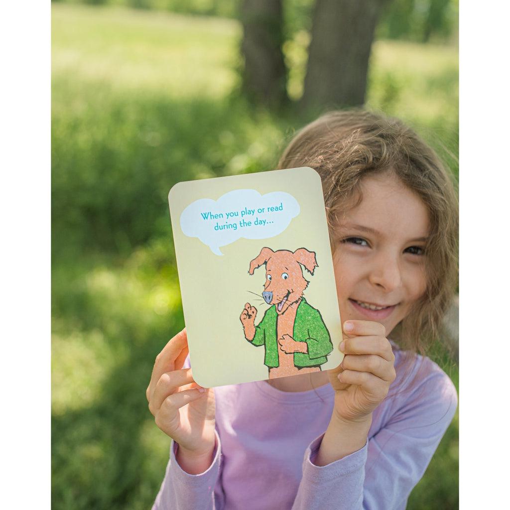 a girl is holding up a card, showing how the card is large in her hands, and not easily lost. 
