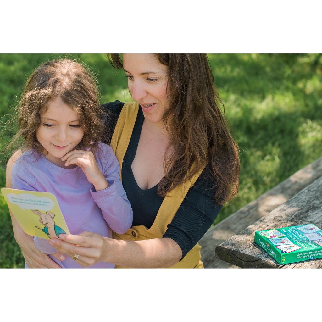 a mom a kid are learning about how to be eco friendly outsite with the cards