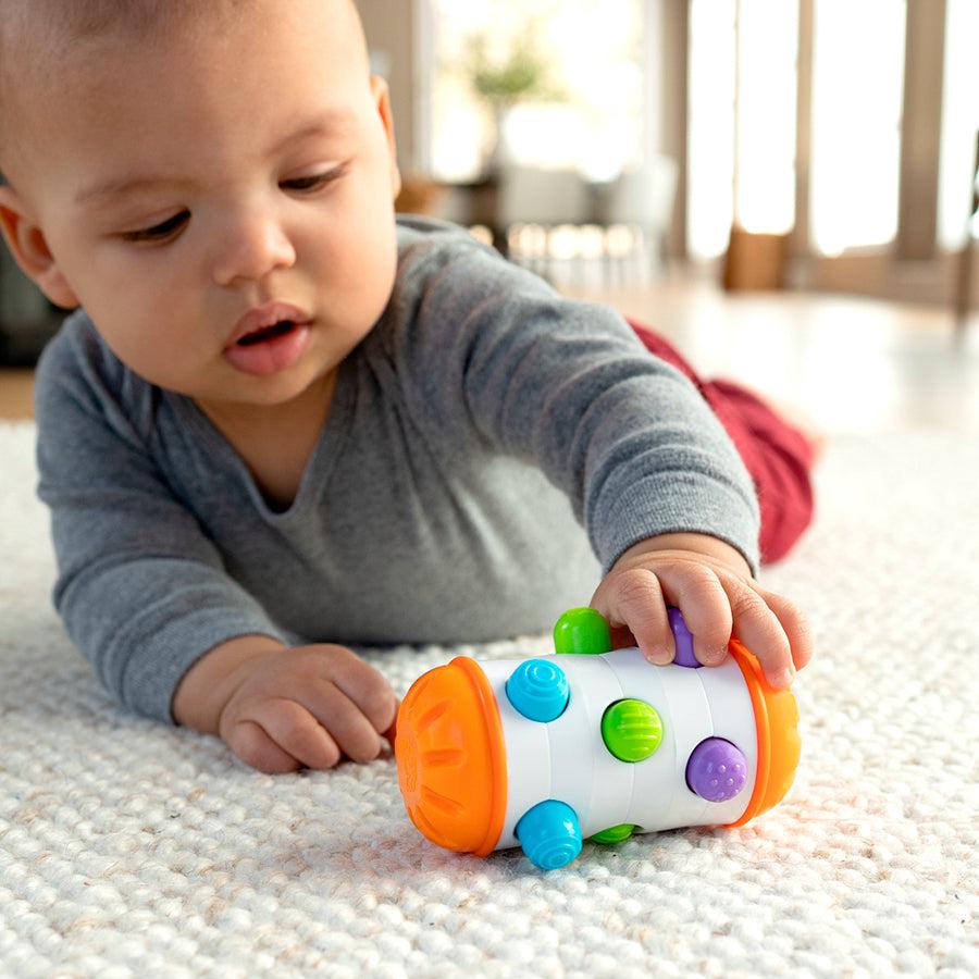 this image shows a baby rolling the toy around. the toy is twice as big as a baby's hand and fun to roll around. 
