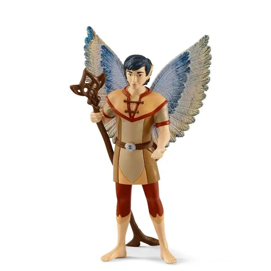 Image of the boy fairy figure. He is wearing an outfit of tan and red skins. He has blue and white feathered wings. He is holding a brown wooden staff.