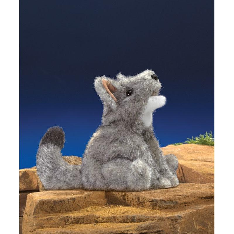 Puppet posed in rocky setting under a night sky. Appears to be howling at the moon. 