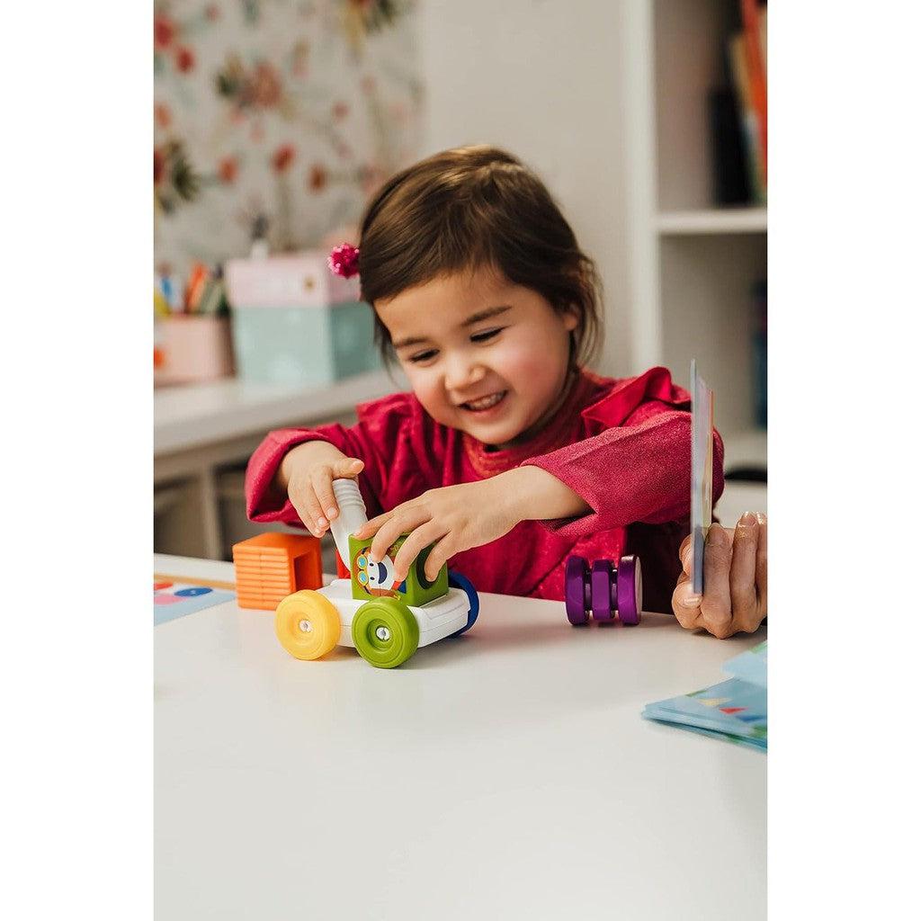 this image shows a child playing with the magnetic blocks. the blocks are big in her hand and safe for a child.
