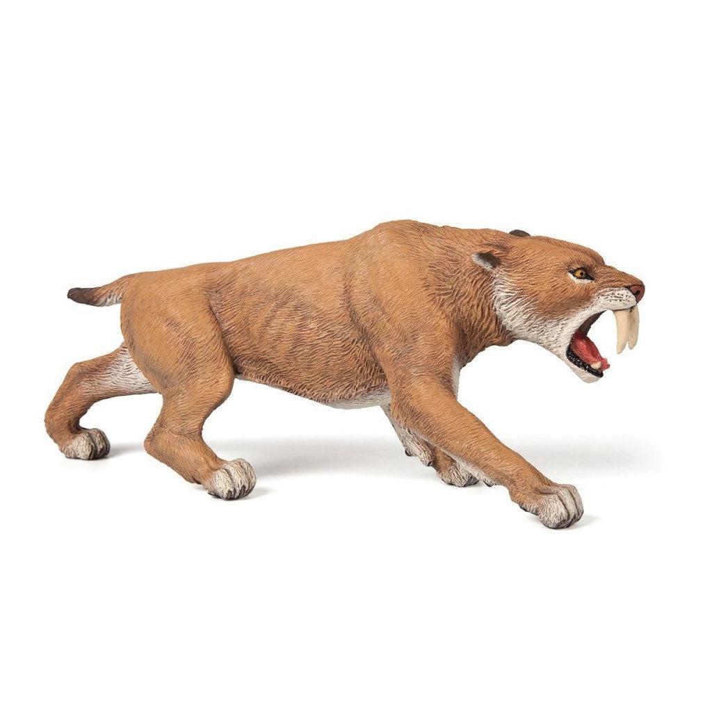 Image of a Smilodon figurine. It is a tan sabertooth tiger looking animal with two long and sharp front teeth.