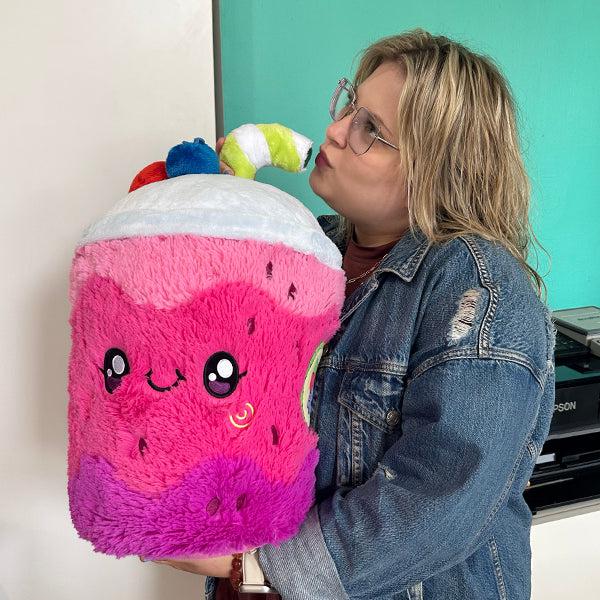 Scene of a woman pretending to drink from the plush.