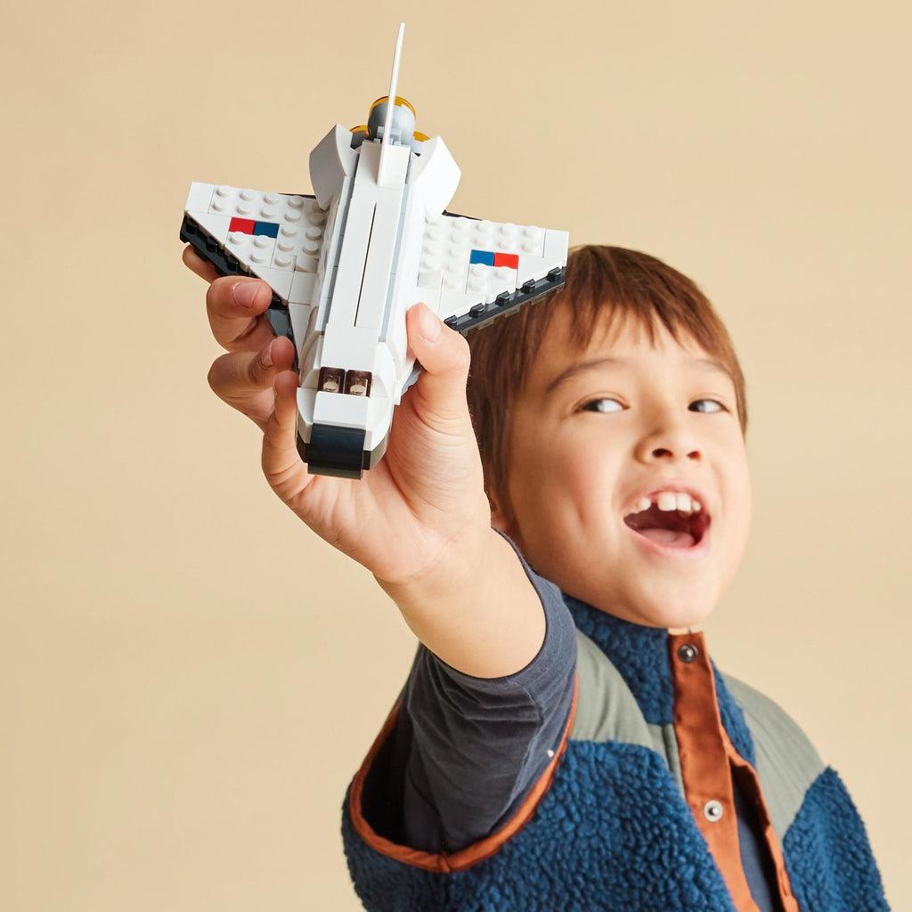 Scene of a little kid holding the fully built classic spaceship build.
