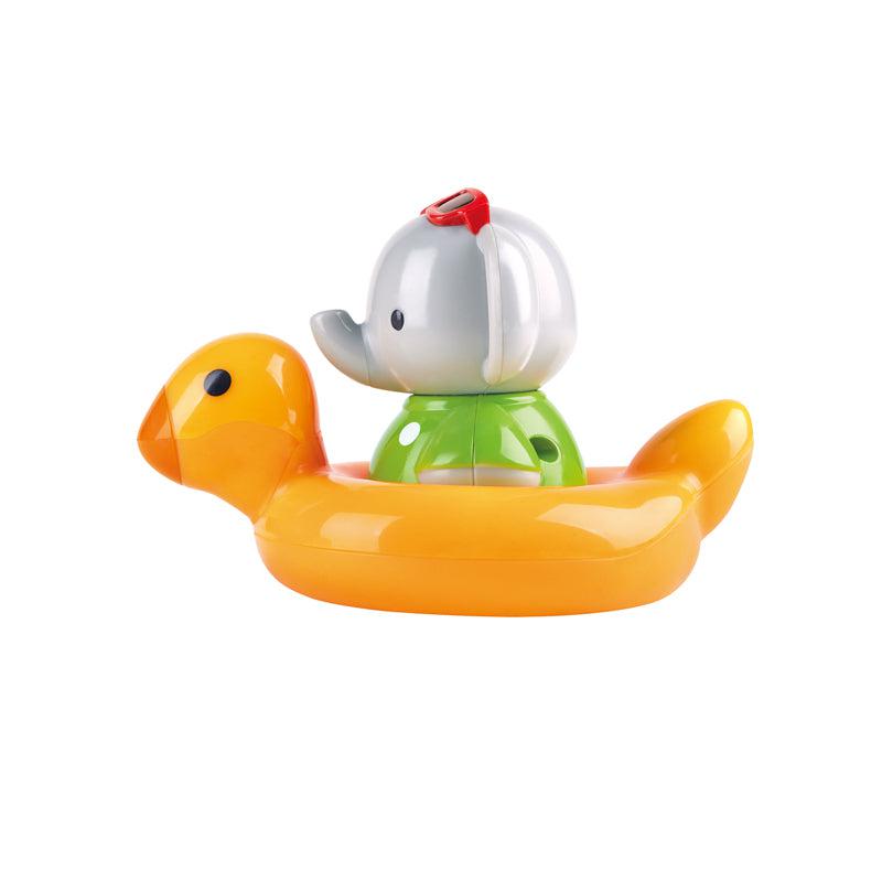 Image of the elephant outside of the packaging. He is wearing a green shirt and red sunglasses and he is riding in a duck inflatable toy.