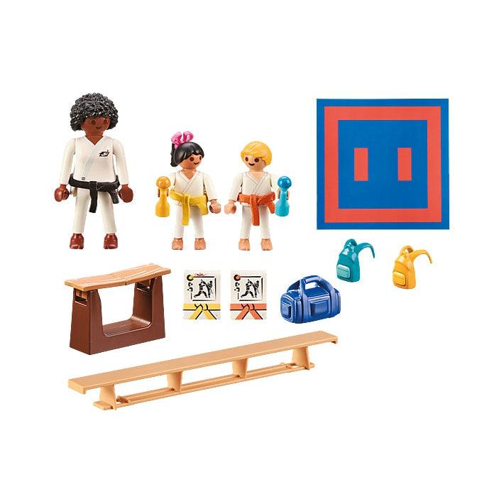 this image shows what is in the set, a mat, two students, a teacher, a board to karate chop, a gag, bench, two backpacks and two certificates