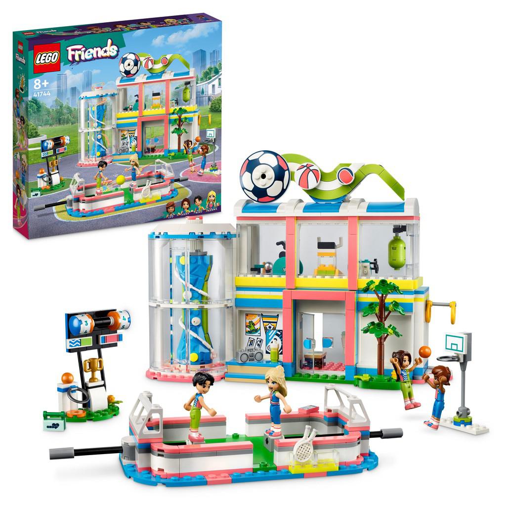teh LEGO friends Sports center is a large building with different rooms and a play area out front for sports