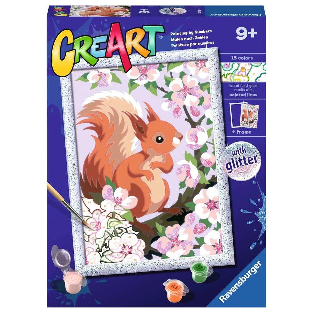 This picture shows the bot for the spring squirrel paint by numbers kit. the painting comes with a glitter frame to capture the painting once it is complete. a squirrel is sitting on a tree as pink flowers blossom around him