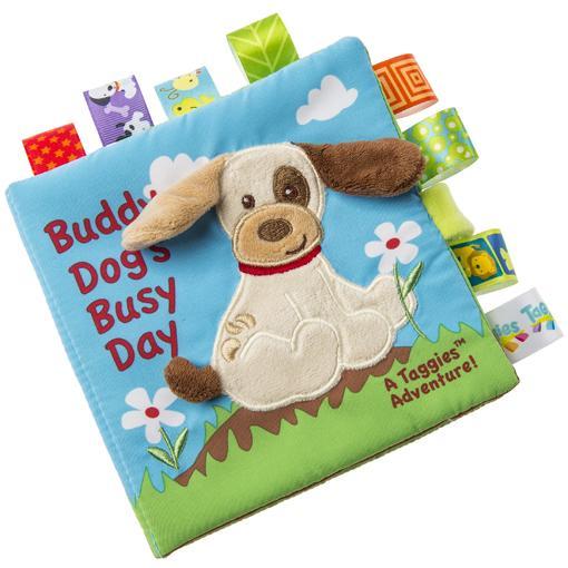 Image of the Buddy Dog Soft Book. The cover of the soft book is an embroidered dog with fluffy ears with the book title "Buddy Dog's Busy Day". Each page in the book has a ribbon tag of varying patterns attached to it.