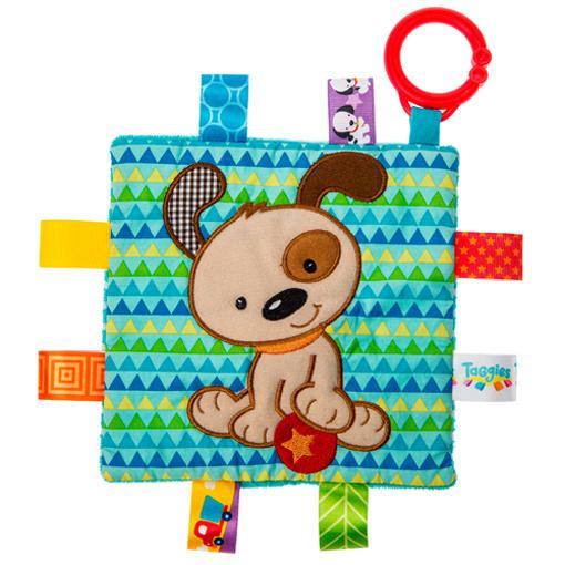 Image of the Taggies Crinkle Me Brother Puppy. On the front is an embroidered brown dog sitting with his paw up on a red ball.. On the edges are ribbon tags made from fabrics that fit the color theme.