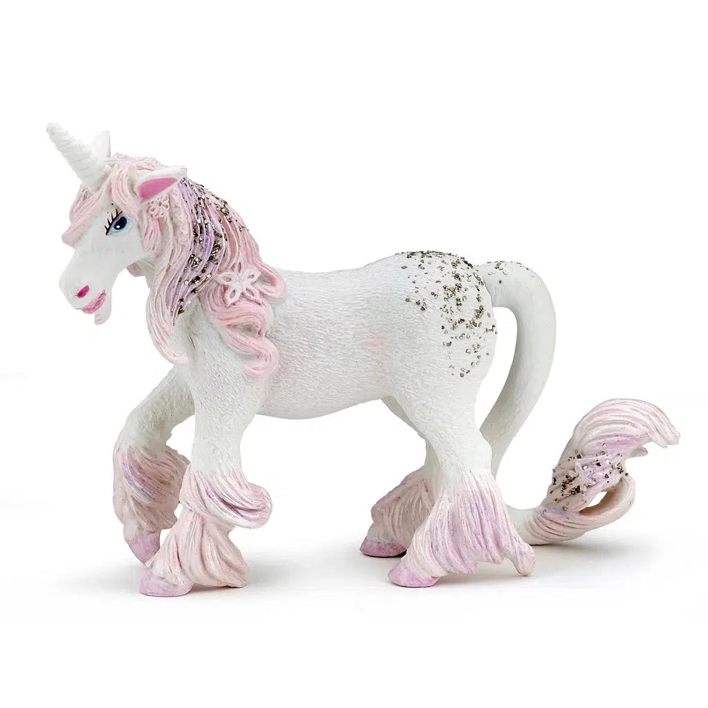 Image of The Enchanted Unicorn figurine. It is a white unicorn with a long pink mane, tail, and tufts of fur above her hooves. She has golden glitter everywhere.
