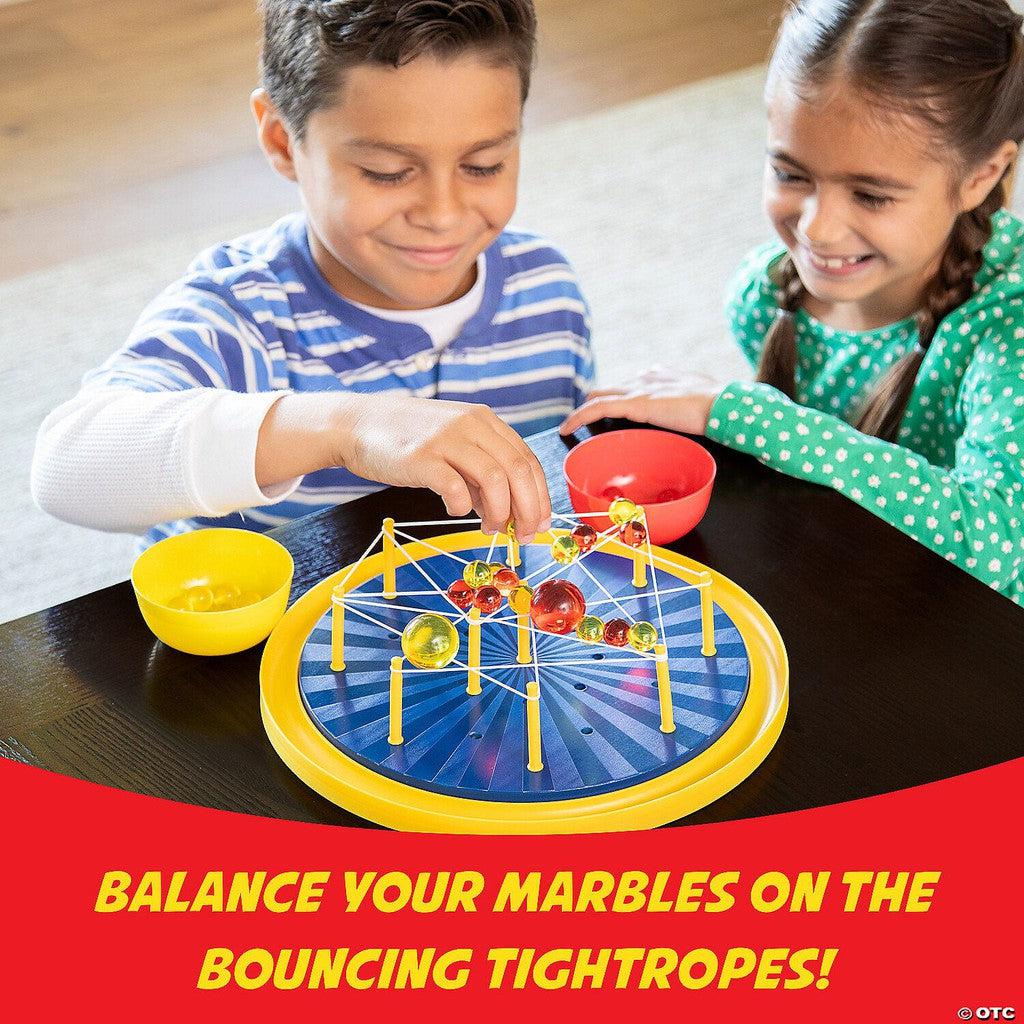 balance your marbles on bouncing tightropes. a boy is putting a marble on the ropes while a girl watches