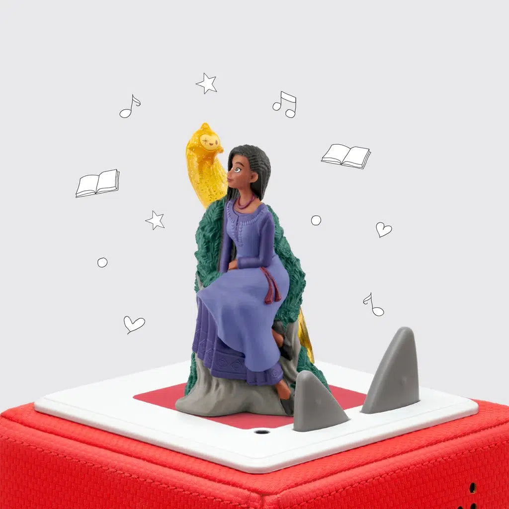 Tonie figure of Asha from Disneys "wish" is shown on top of a toniebox. She is in a long blue dress and a shooting star character is next to her shoulder.