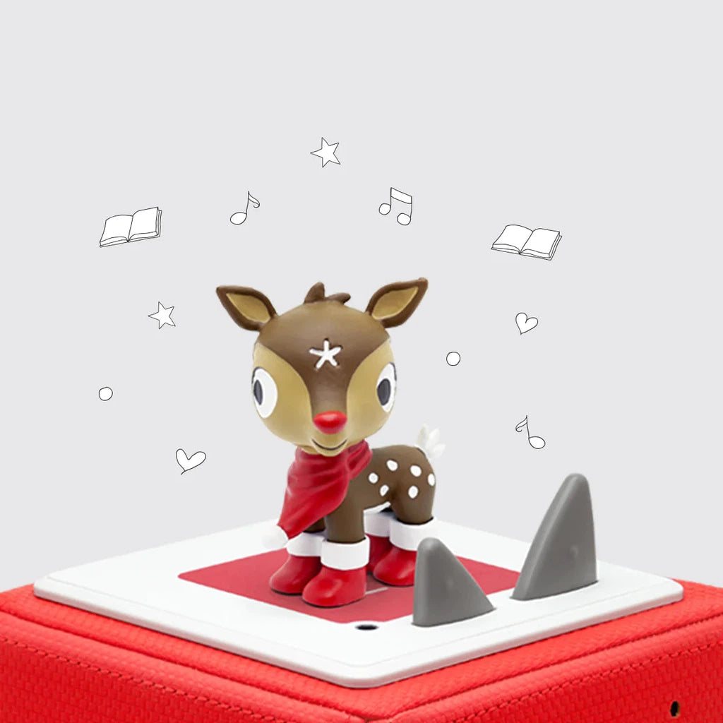 A reindeer figurine wearing a red scarf is sitting on top of a red box.