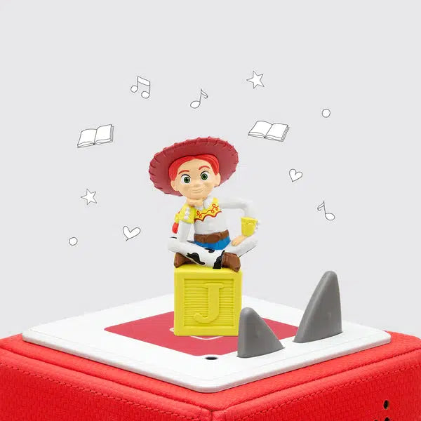 Tonie figure on a toniebox. The figure is jessie from toy story sitting on a yellow block with the letter J