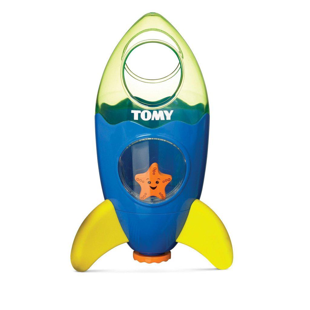 Image of the toy outside of the packaging. It is a rocket with a blue body, clear green top, and yellow legs. there is a window where you can see a starfish hiding inside.