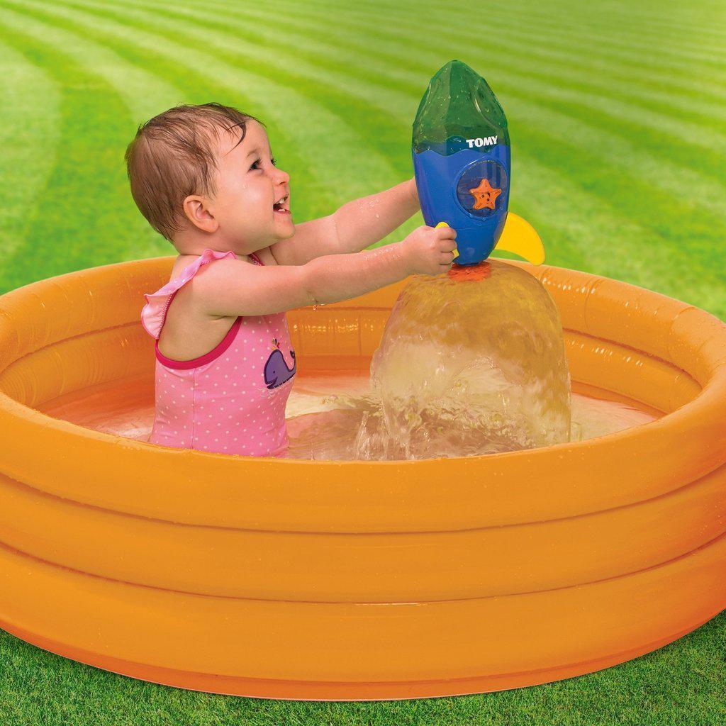 Scene of a child playing with the bath toy in a plastic pool outdoors.