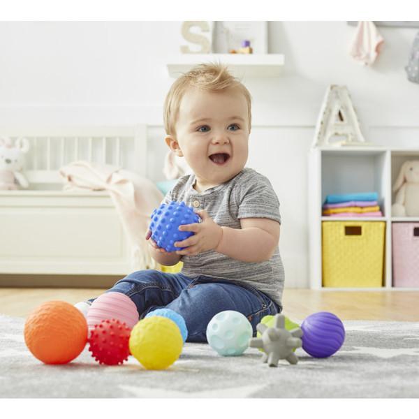 Scene of a small child playing with and holding the balls.