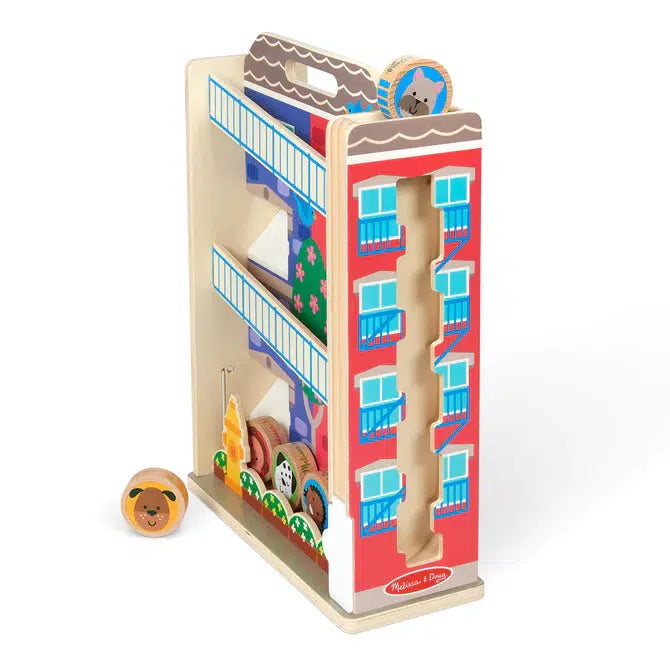 Shows that on one of the sides of the town house tumble toy, there is another different tumble path. It goes straight down in a zigzag pattern and exits to the front of the toy.