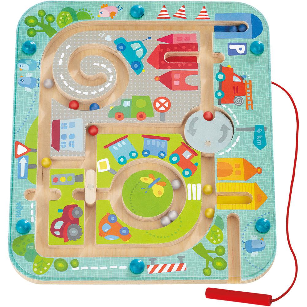 Image of the toy outside of the packaging. It is a fake town map on a board with magnetic balls running through it. Using a stylus, you can move the balls around the town! The cartoonish art for the town features large cars and houses with some plants and animals.