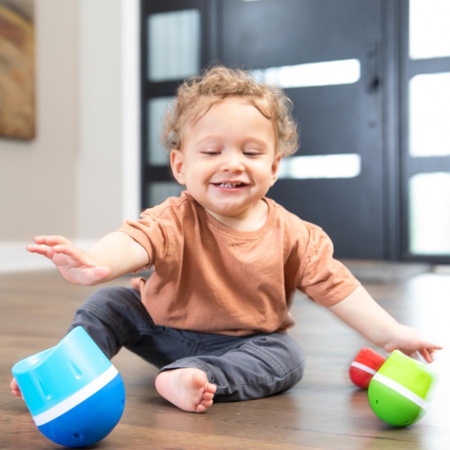 Scene of a little boy smiling while playing with the toy.