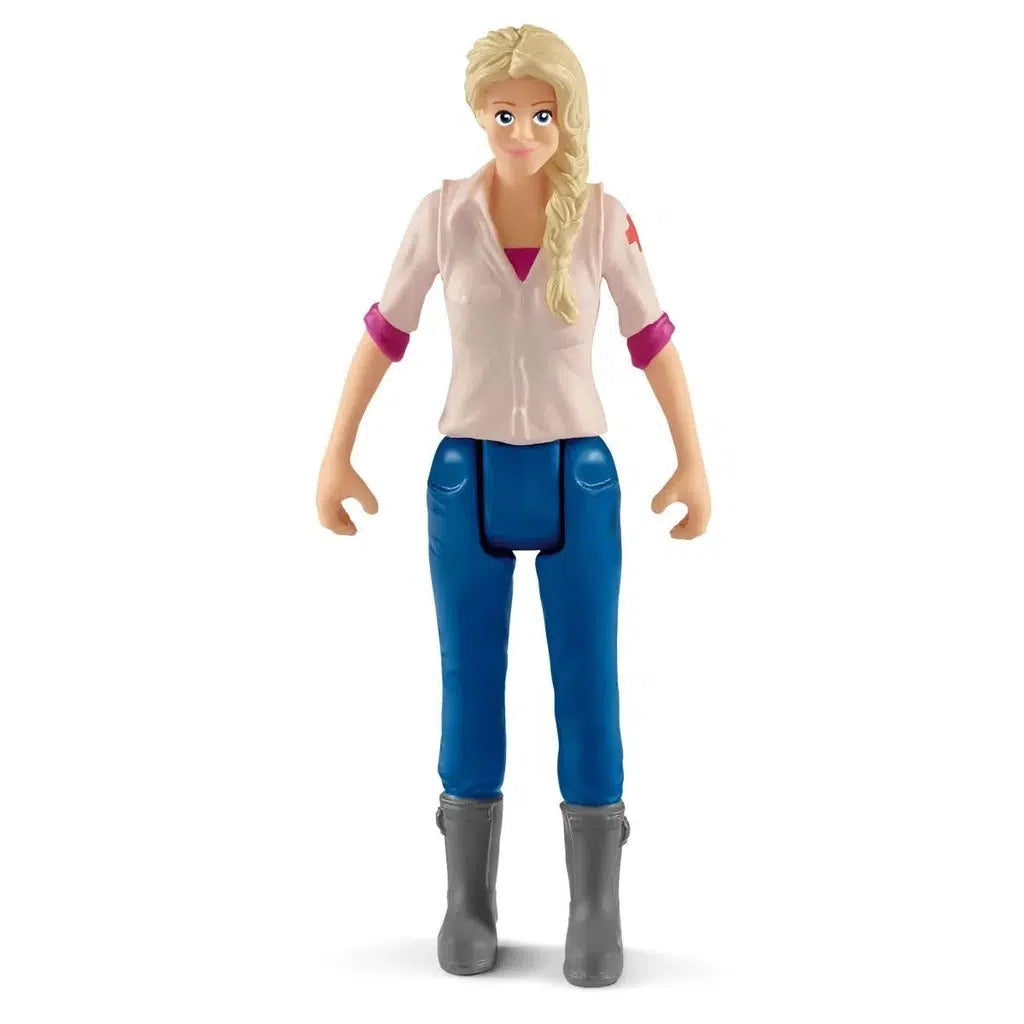 Close up of the veterinarian figure. She is wearing an official first aid logo shirt and long blue pants. Her blonde hair is braided to the side.