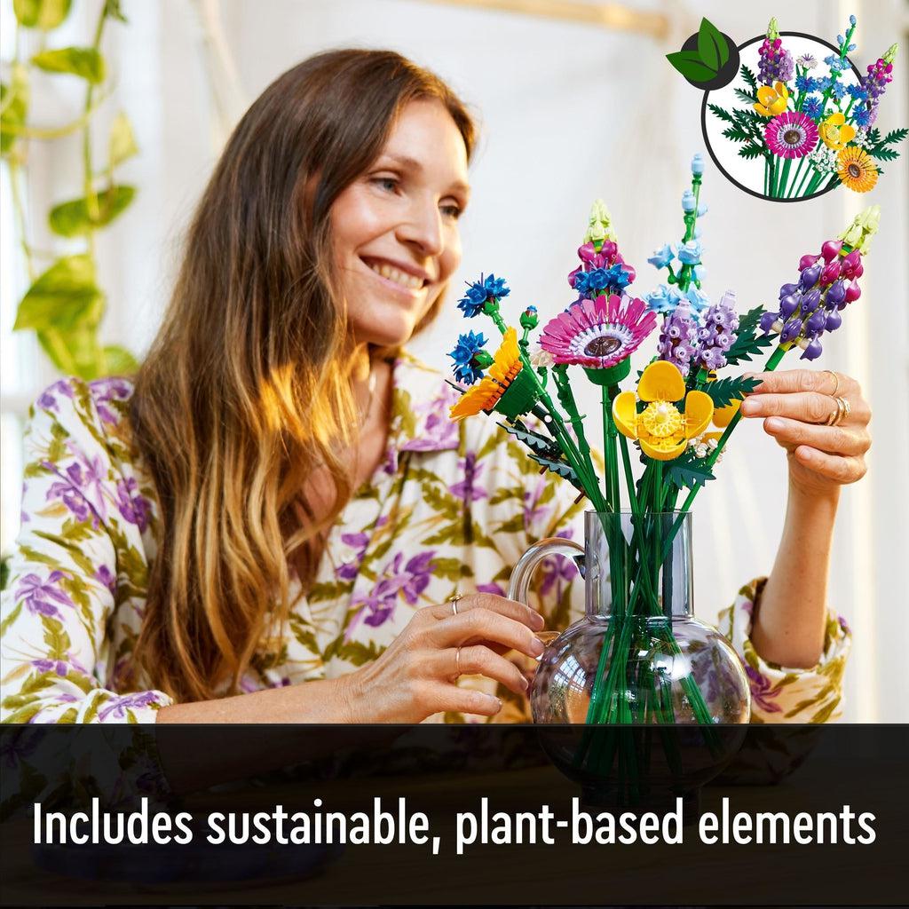 Image of a woman arranging the LEGO flowers in a vase and smiling. Caption: Includes sustainable, plant-based elements