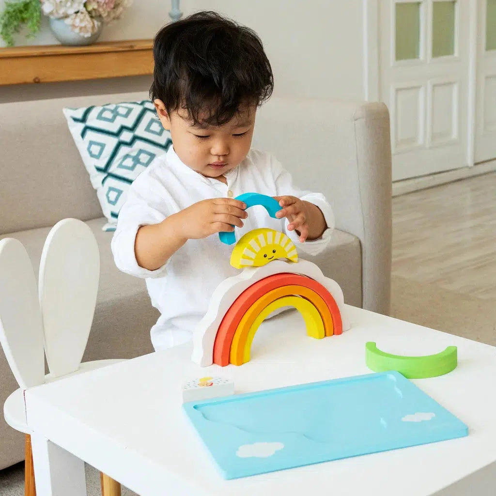 a baby is playing with the rainbow blocks