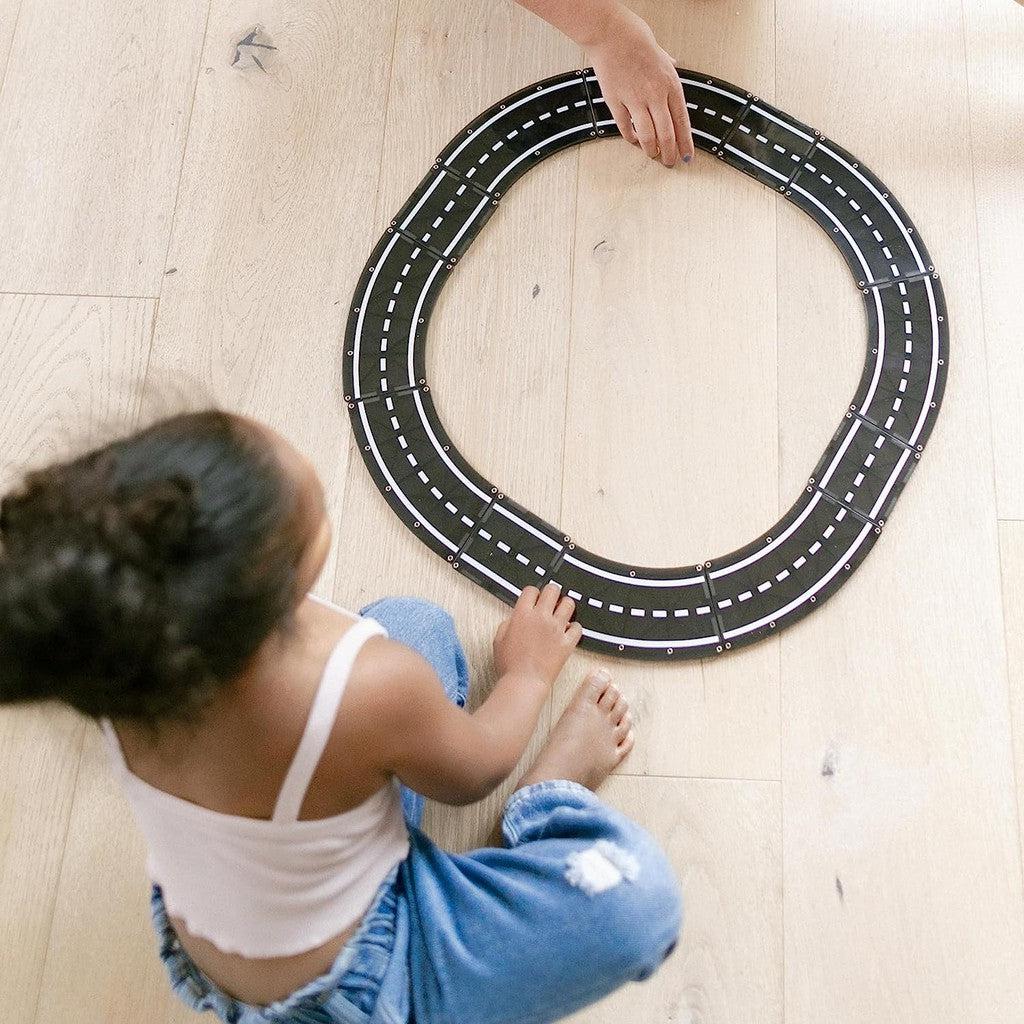 a child is playing with the road, they bult a circle