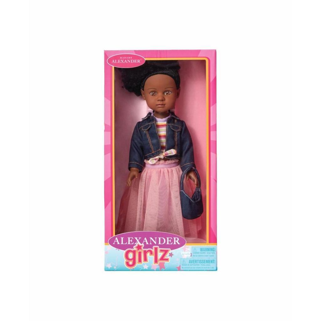 A fashion doll with dark skin and curly hair, dressed in a denim jacket and pink skirt, displayed in a pink "Alexander Girlz" branded box.