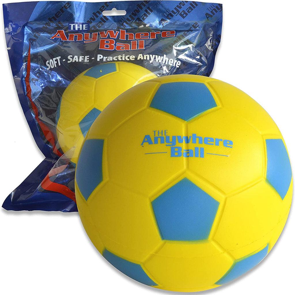 A foam soccer ball with blue text reading: The anywhere ball. The base of the ball is yellow and the highlights that would be black on a normal soccer ball are blue. The ball sits in front of another ball inside the vacuum sealed packaging they come in. The packaging reads: The anywhere ball soft - safe - practice anywhere.