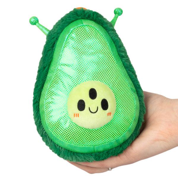 Image of the Alien Avocado Snacker squishable. It is a lime green sparkly avocado. It has three eyes and antennas.