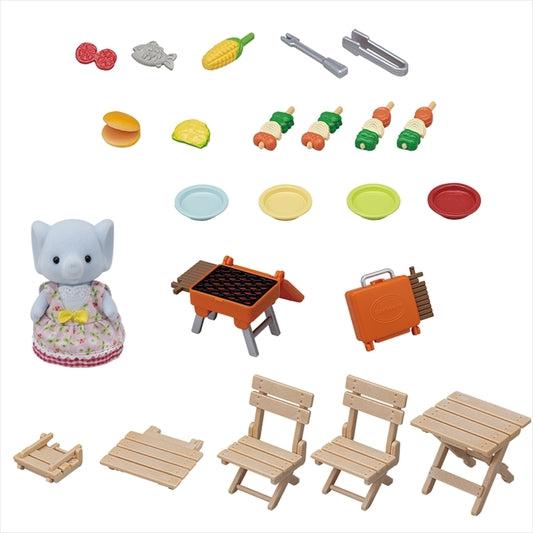 Image of all the included pieces. The set comes with an elephant girl wearing a dress, a barbeque (that folds), two picnic chairs (also folds), picnic table (also folds), four plates of various colors, grill tools, and assorted food items.