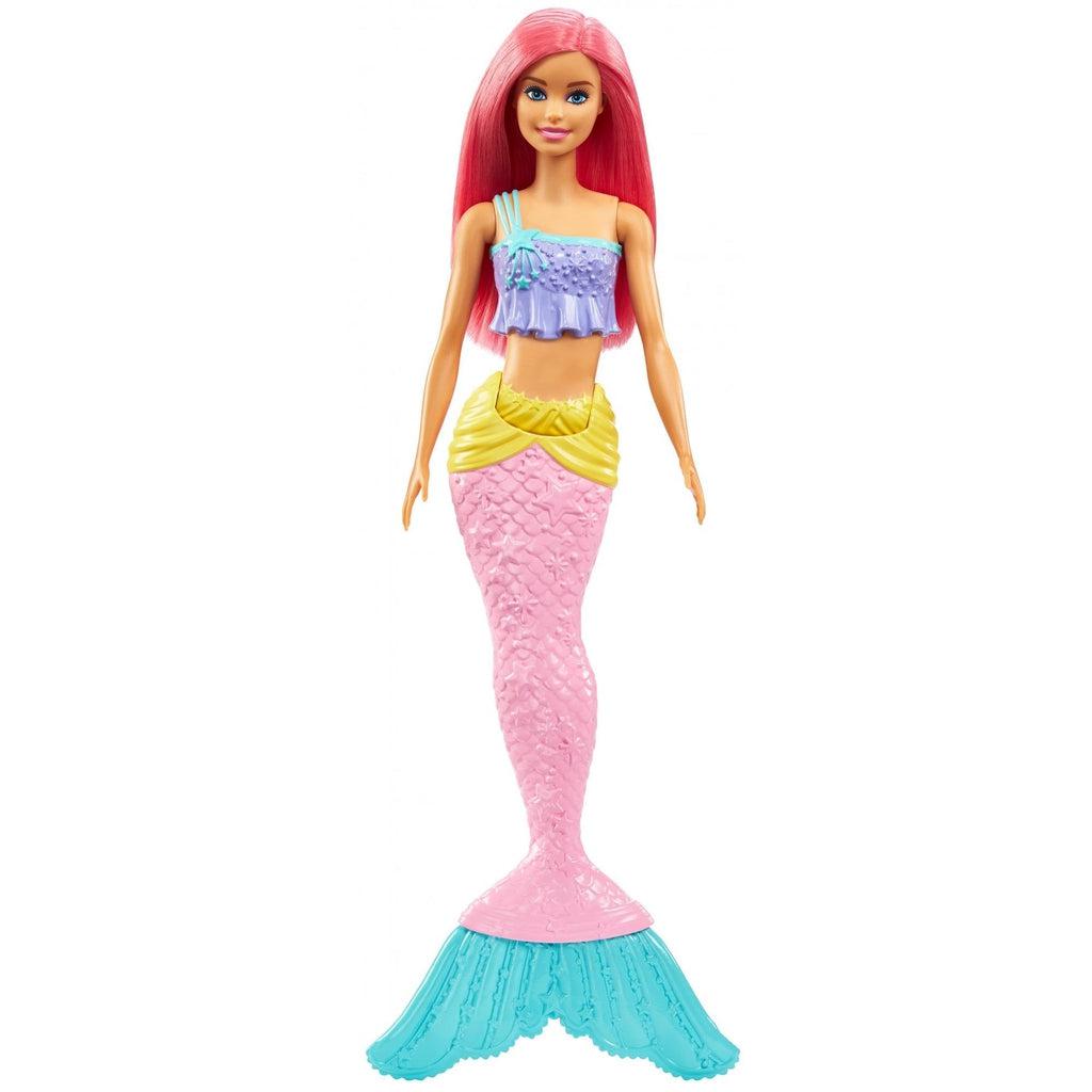 The barbie is shown out of it's box. It has pink hair, a purple crop top, a yellow sash at the waist, and a pink mermaid tail with blue fins at the end