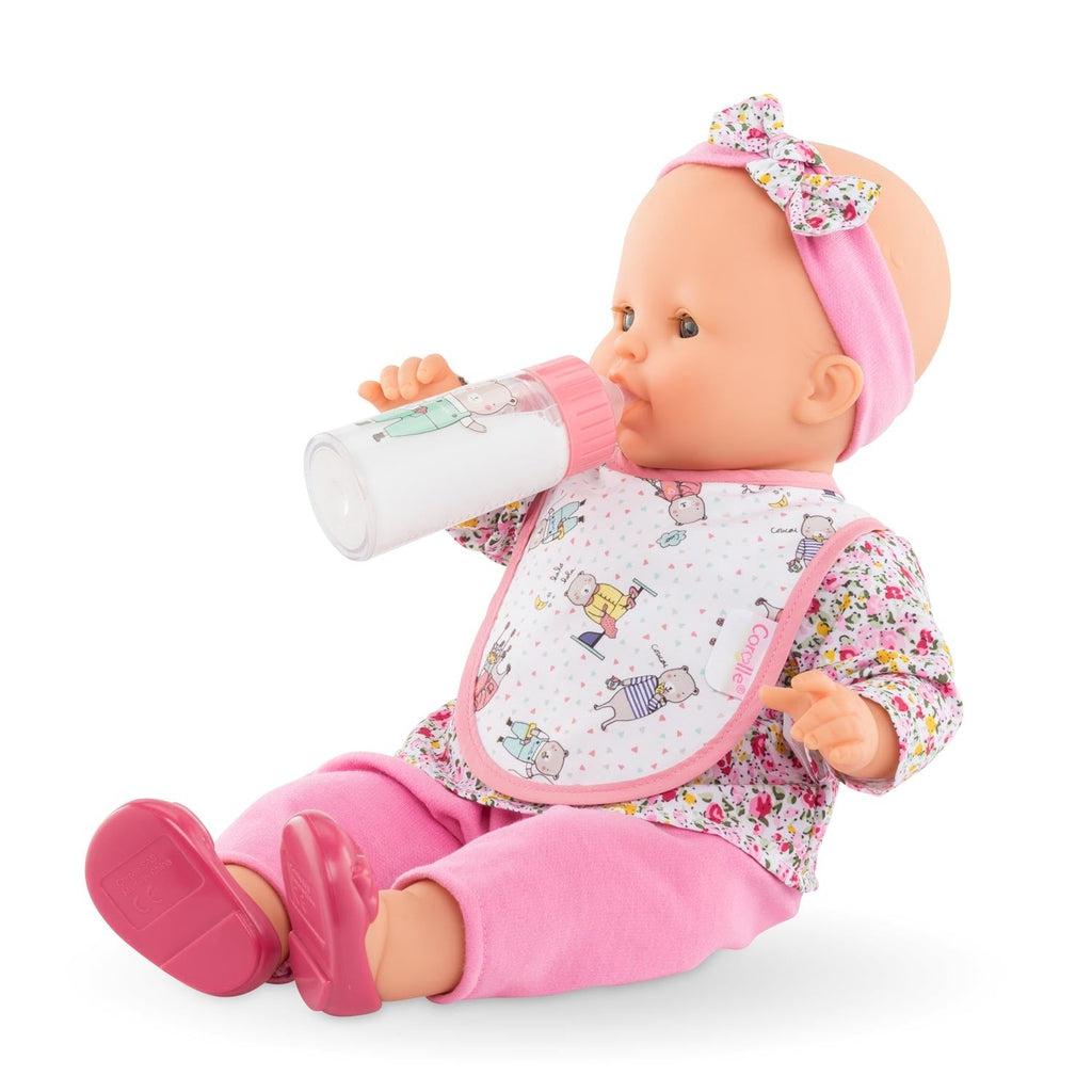 A baby doll can be seen with the bib on and the bottle in its mouth