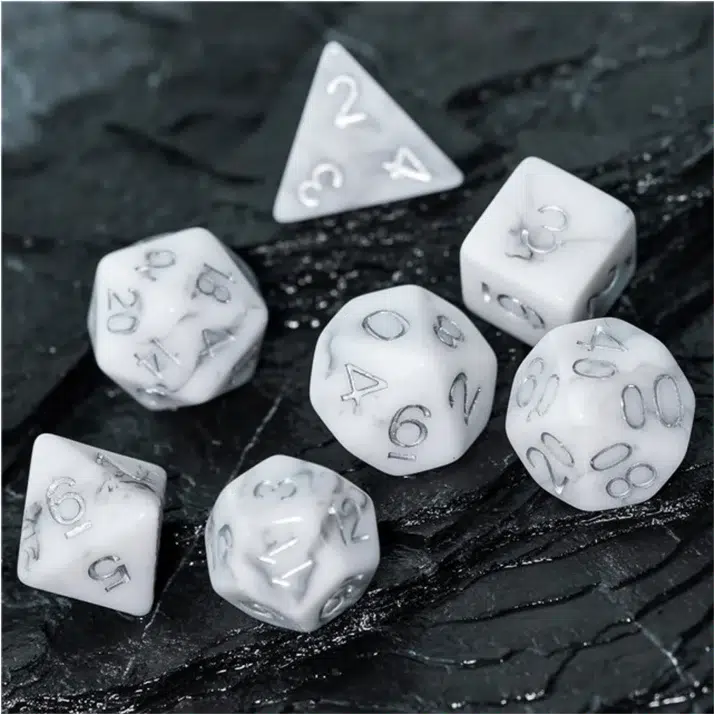 The dice are shown again but placed on a rock that looks to be obsidian.