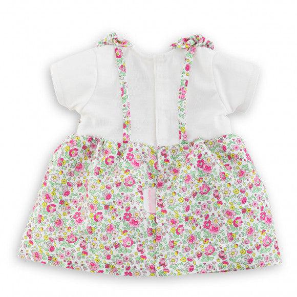 The doll dress is a white shirt under a flower print dress in an apron like style with straps for the shoulders
