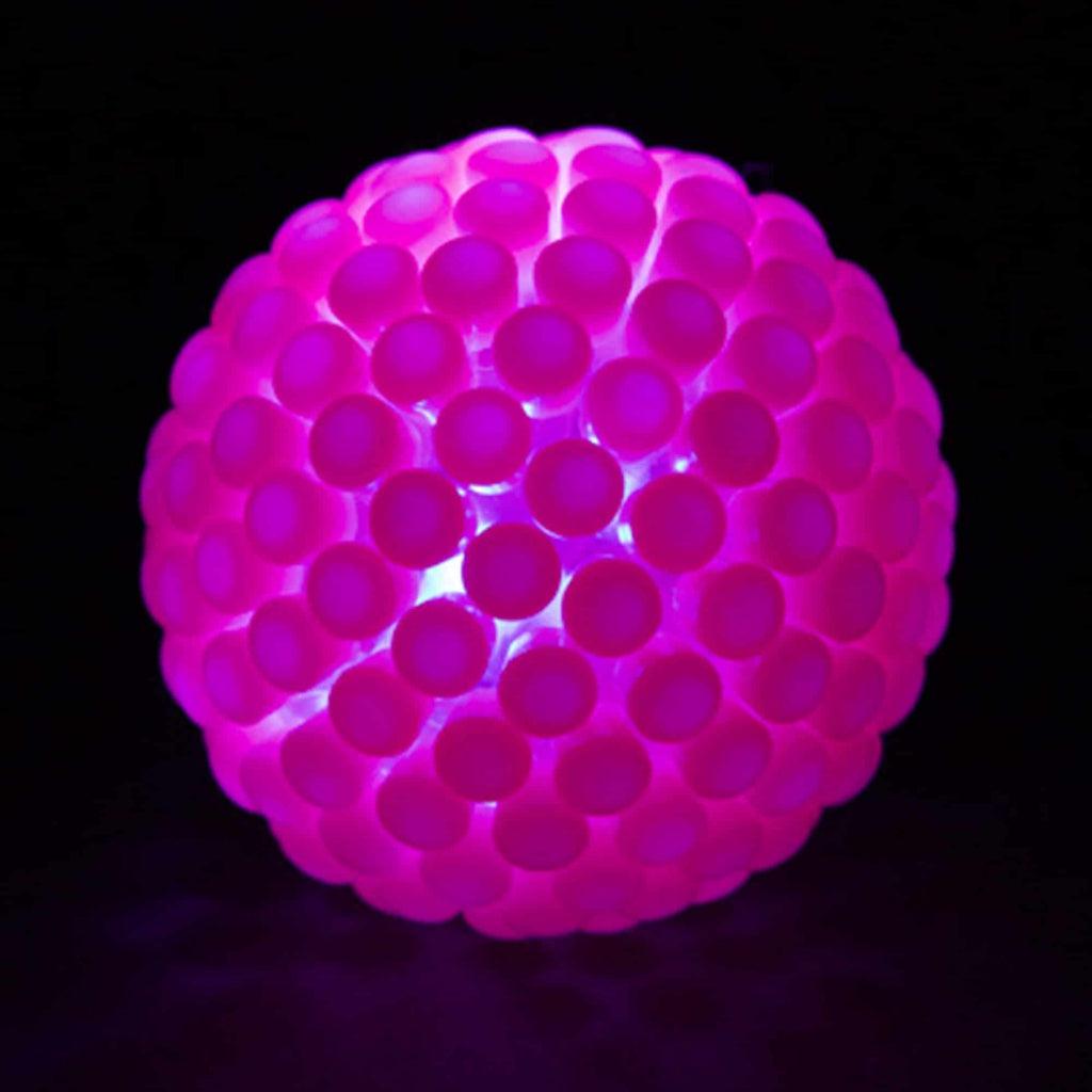 A bright ball is shown with pink caps attached to every available spot on the ball, the ball is glowing with a pink light due to the caps applying a pink tint to light that passes through
