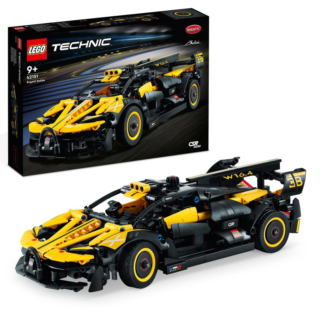 The lego set is shown in front of its box | the set is a black and yellow car that looks more like a framework rather than a solid car, the exterior is made up of pipes and segmented panels.