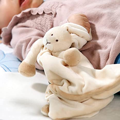 Image shows the blanket slightly bunched up with the rabbit head and arms still visible. The blanket it set next to the arm of a baby