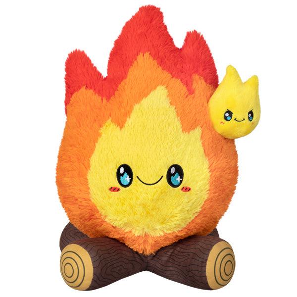 Image of the Campfire squishable. It is a happy fire with dazzling blue eyes sitting on top of two crossed logs.